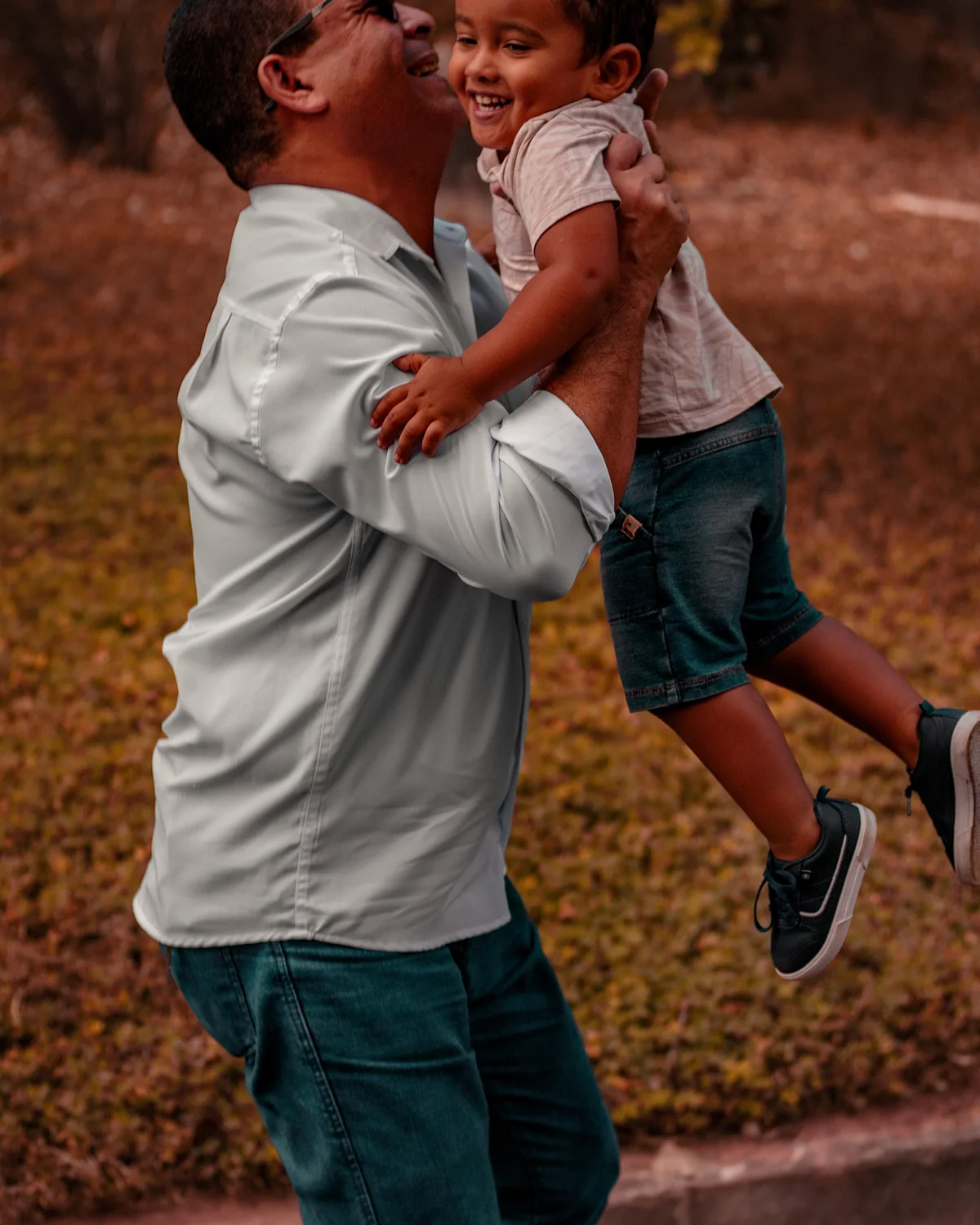 Pai erguendo o filho durante um registro espontâneo em família